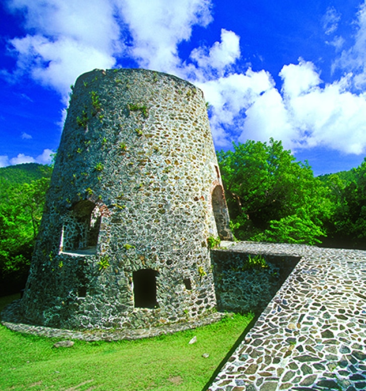 a stone tower with a walkway and trees